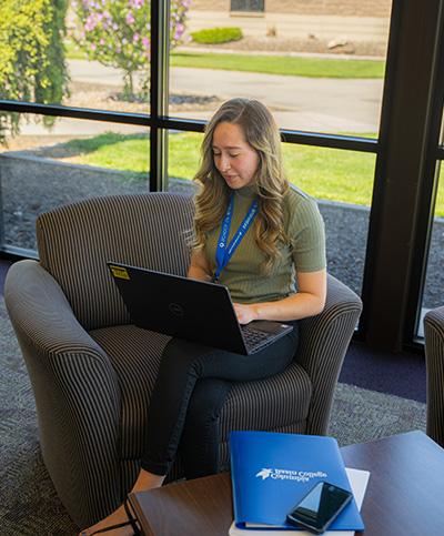 Student sitting in grass with laptop open